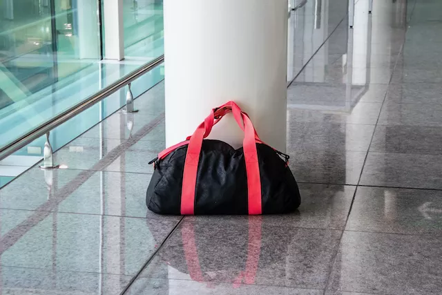 Suspicious Black Bag With a Red Handle